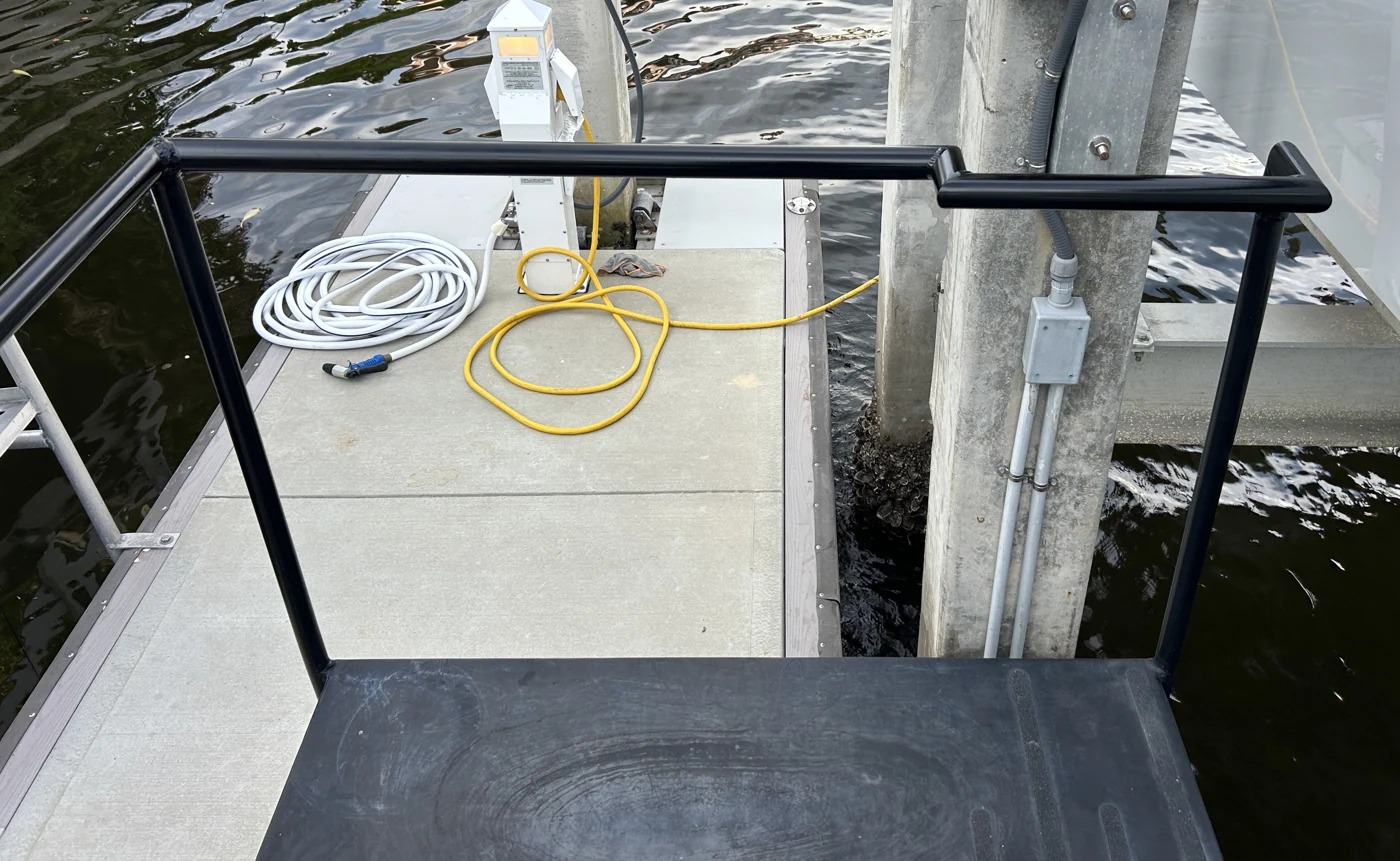 Finished black metal handrail installed at a waterfront dock