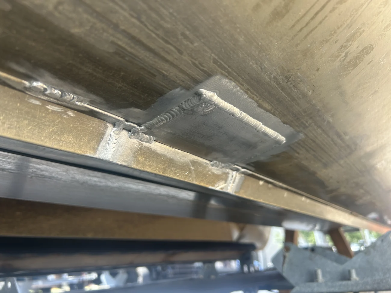 Welded aluminum patch repair on the underside of a pontoon