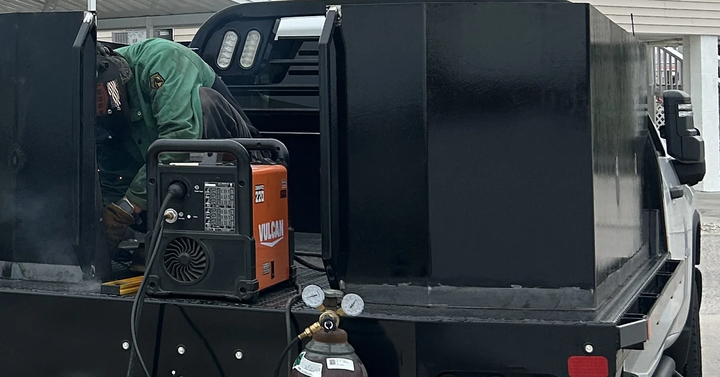 On-site welding work on a steel truck assembly